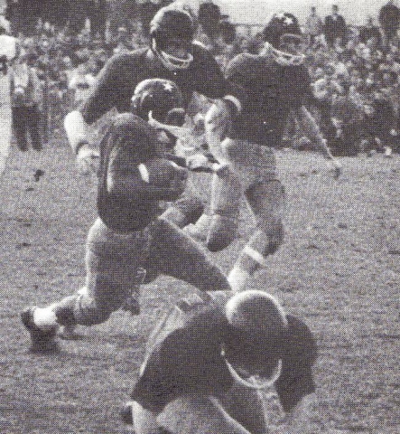 Woody White takes the ball for a ride against Clark 63 season. Notice the leather helmets.